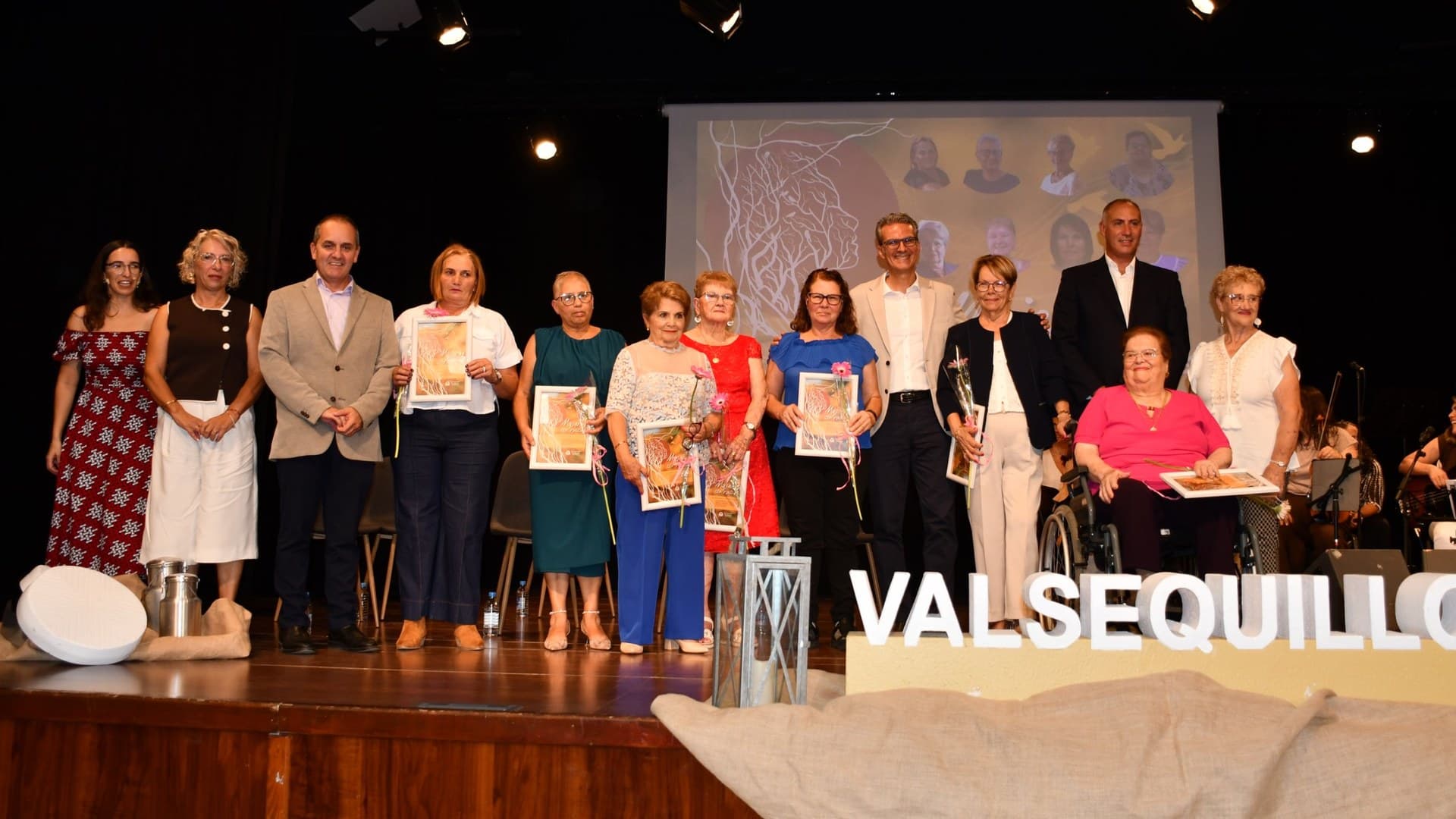 Las ocho homenajeadas posan en el escenario del Teatro Jacinto Suárez Martel con sus placas y flores, junto a representantes municipales.